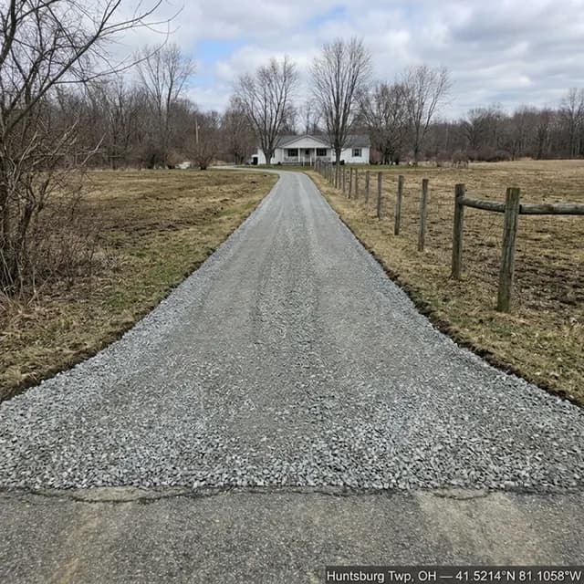 The same Huntsburg Township, Ohio driveway after restoration — a firm, evenly crowned gravel surface running from the road apron to the house